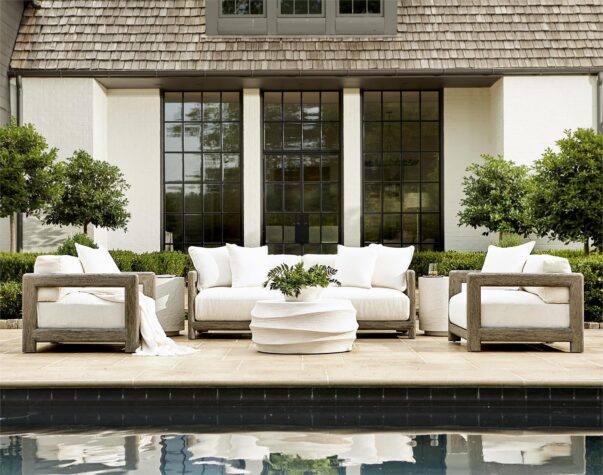 the montaigne outdoor sofa and two chairs outside a luxury home and pool