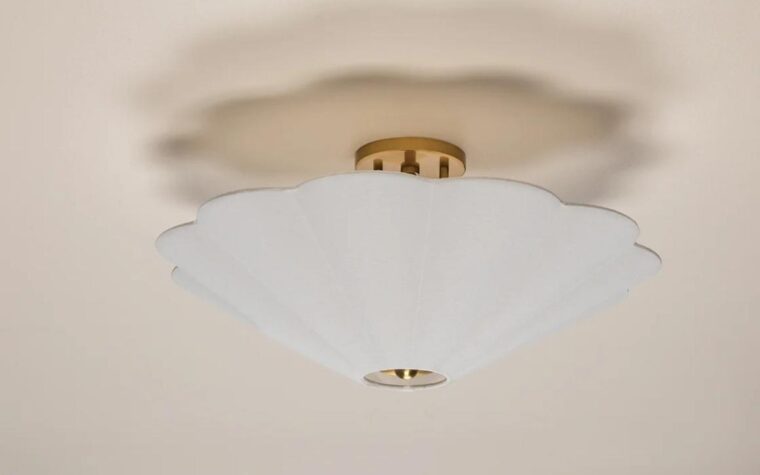 a flush mount ceiling light with white and gold accents made to look like a flower