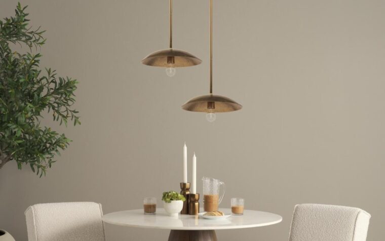 two gold pendants with a hammered finish above a dining table with morning coffee