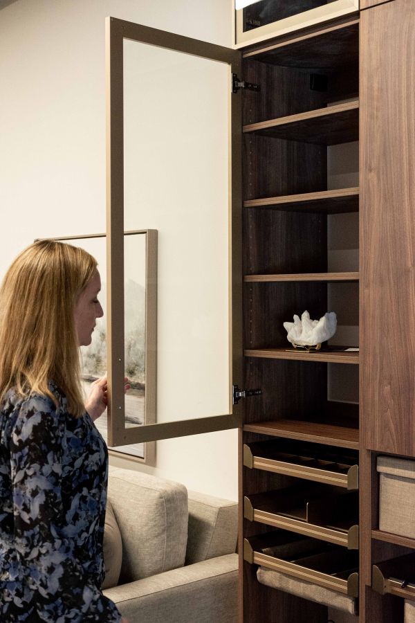 woman opening closet door of essential closet program
