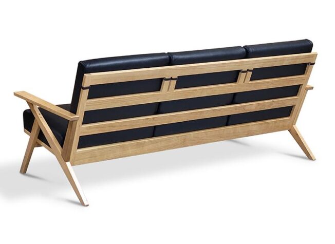 Exposed wood frame sofa with exposed horizontal slats on the back