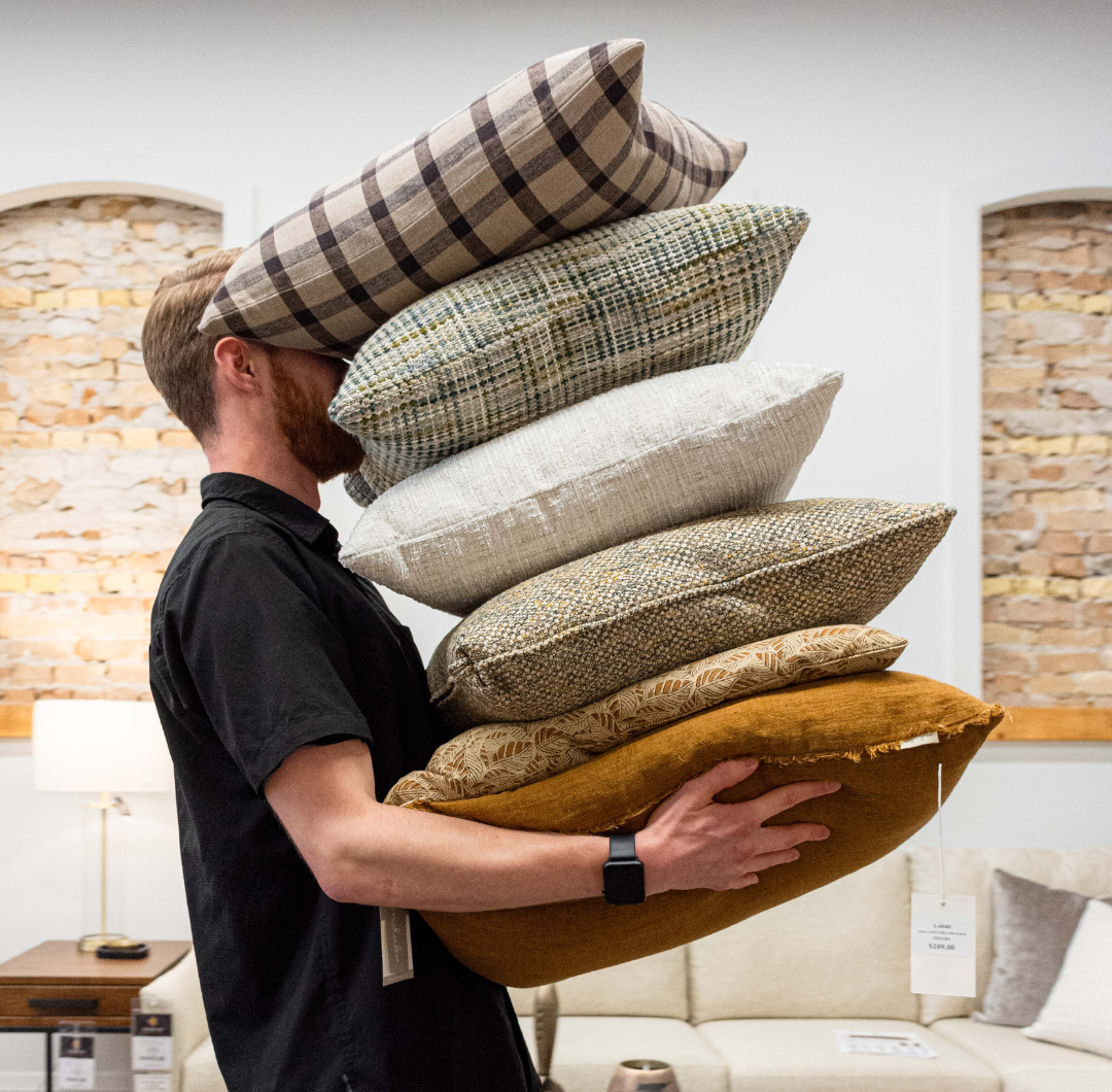 Carter with his hands full of pillows